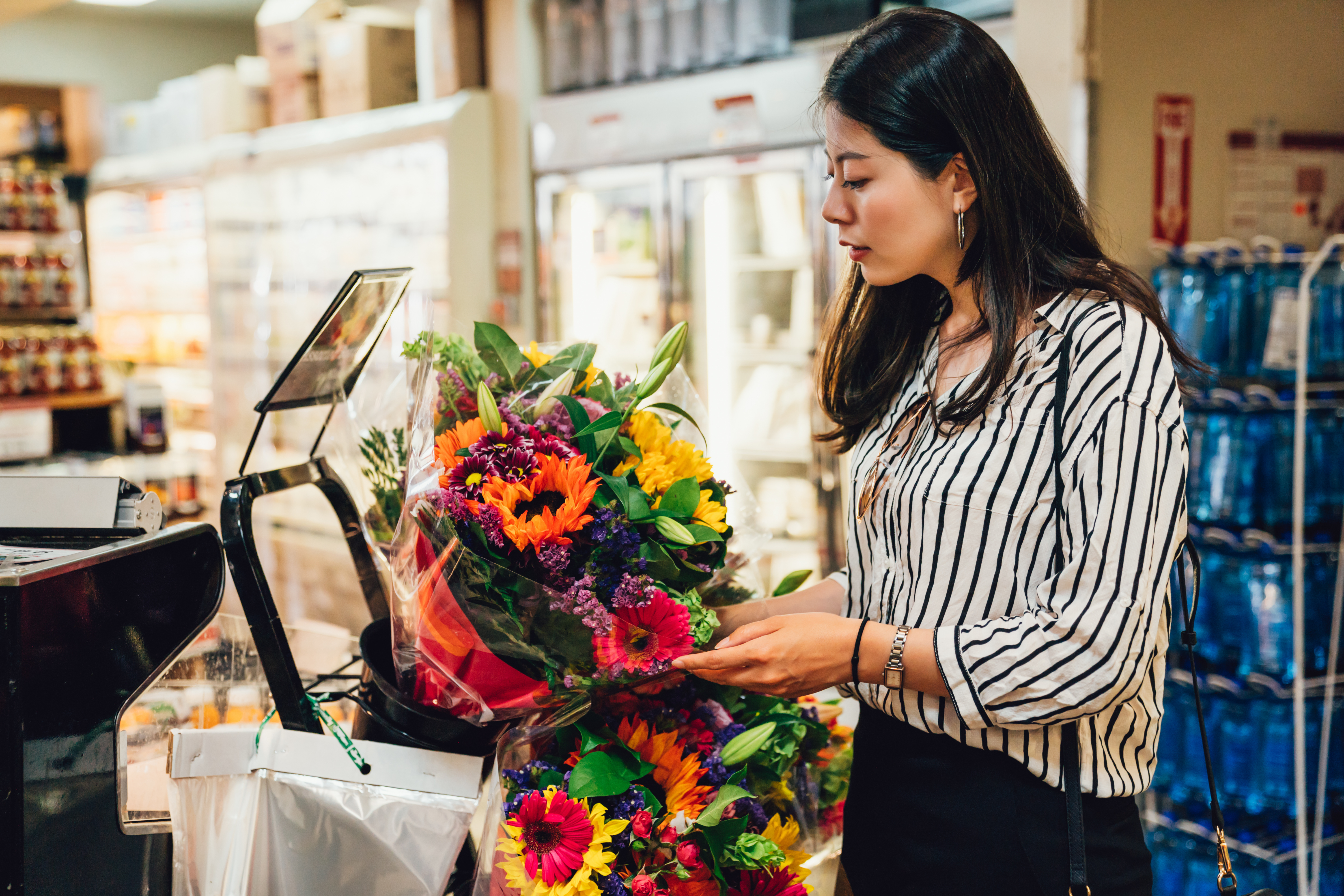 Mulher no checkout com buquê de flores