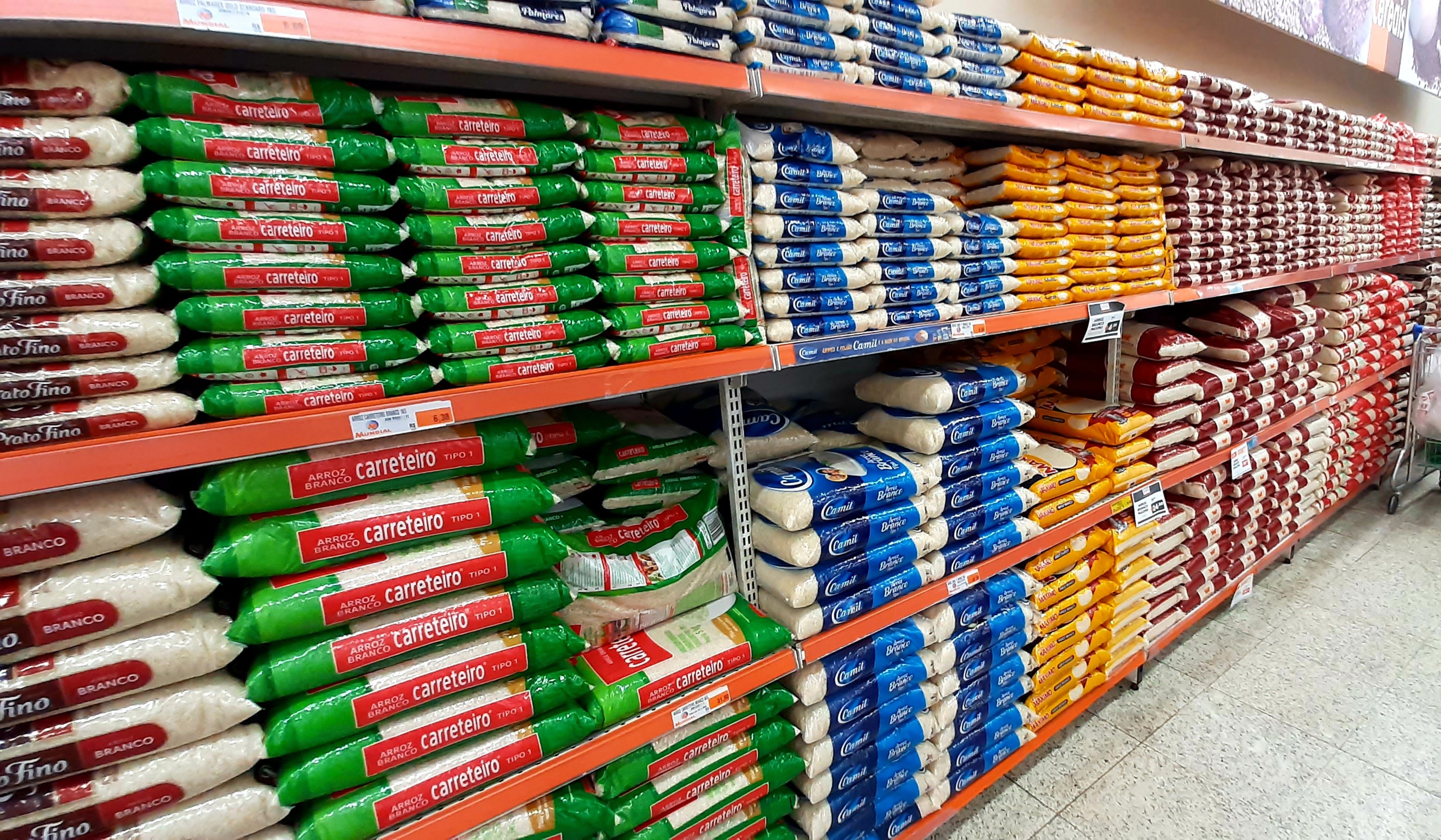 Foto do Adobe Stock de gôndola de supermercado com pacotes de arroz